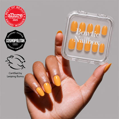 Sunset Orange press-on nails on hand - lifestyle photo, jelly glaze finish