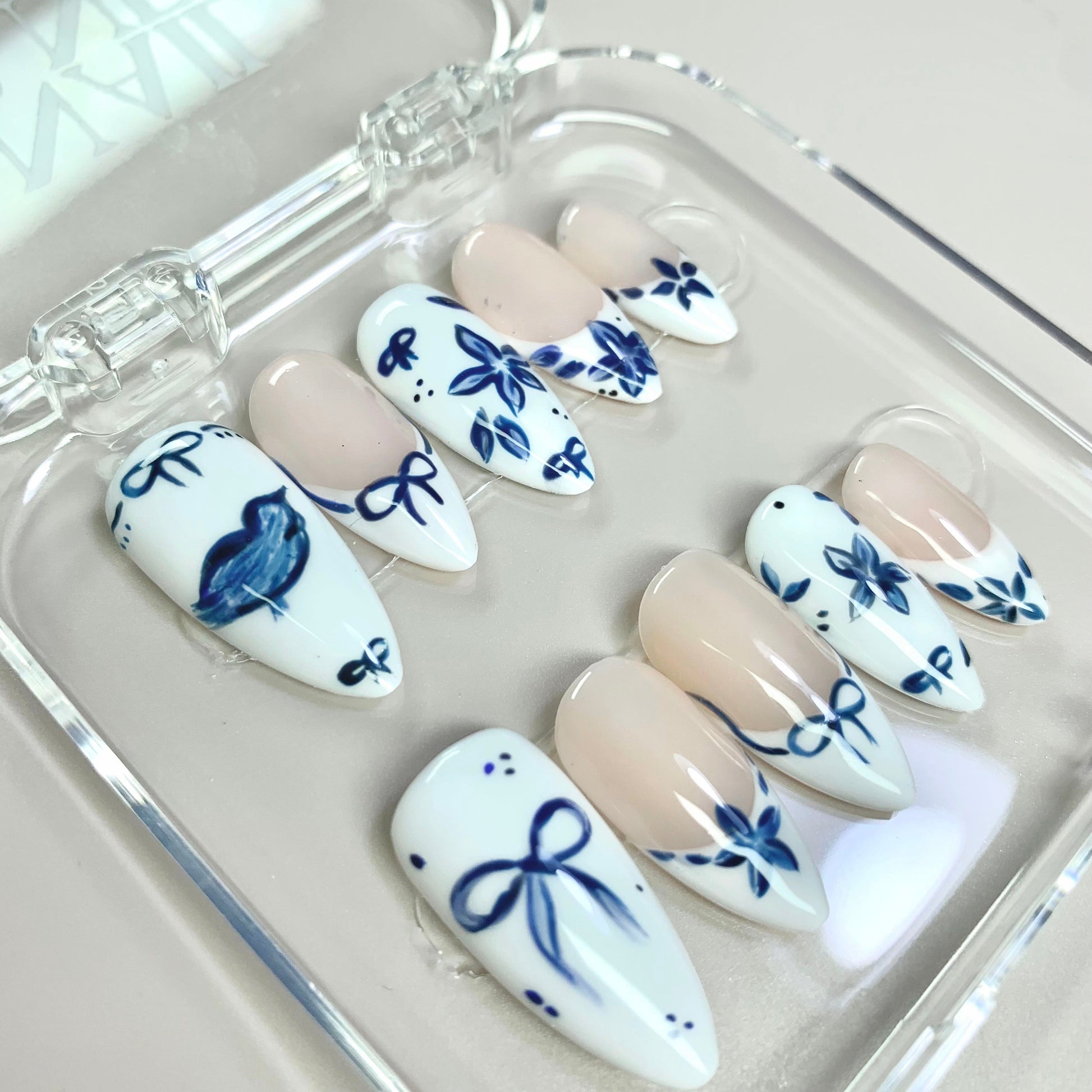 Ceramic Blue press-on nails on hand - lifestyle photo, milky cloud dancer finish